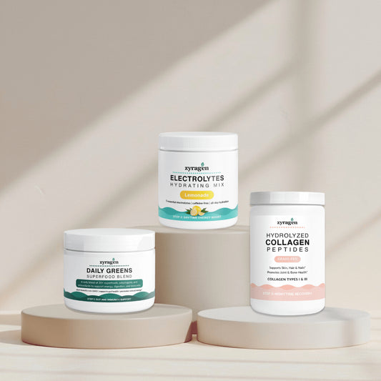 Zyragen The Daily Ritual supplement containers on a neutral background. A tub of Daily Greens, a tub of Electrolytes in Lemonade flavor and a tub of Collagen.