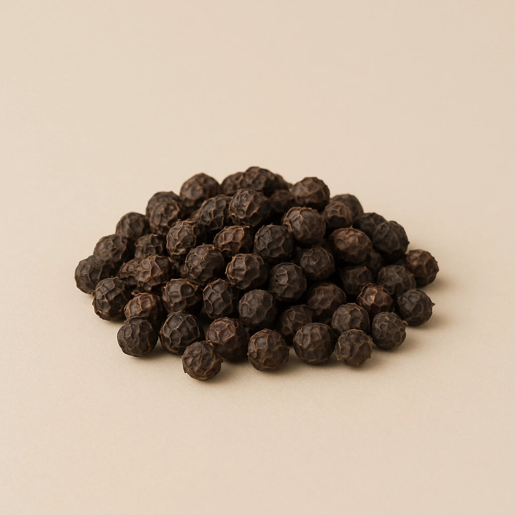 Black peppercorns on light background
